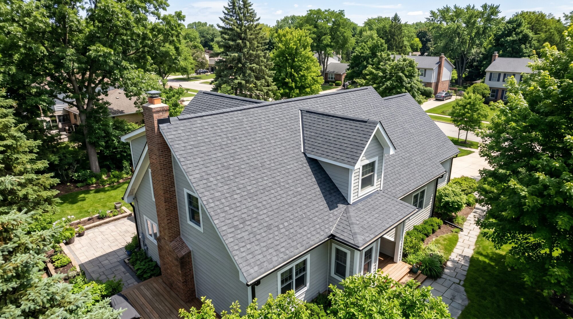 Aerial view of a home with a new architectural asphalt-shingle roof and brick chimney